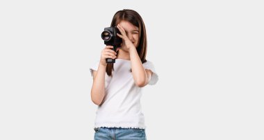 Full body little girl excited and entertained, looking through a film camera, looking for an interesting shot, recording a movie, executive producer clipart