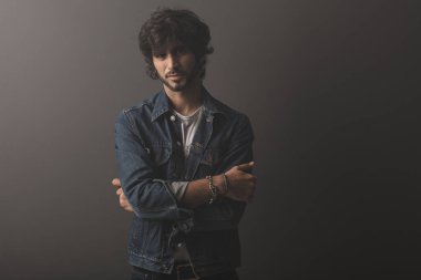 Genç yakışıklı adam neşeli ve kendine güvenen Studio kamera bakıyor 