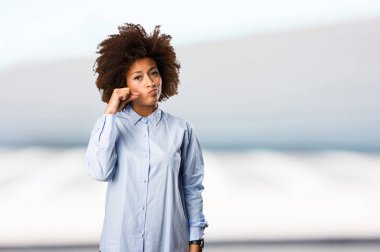 Genç siyah kadın mavi gömlekli arka plan bulanık sessizlik jest yapıyor