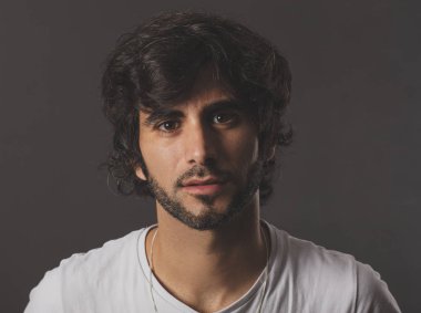 Genç yakışıklı adam neşeli ve kendine güvenen Studio kamera bakıyor 