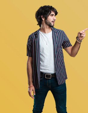 Sürpriz bir şey, doğal ve rahat sunan gülümseyen genç yakışıklı adam tarafına işaret