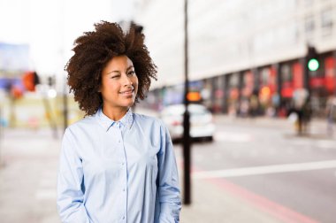 bulanık arka plan üzerinde duran genç siyah kadın