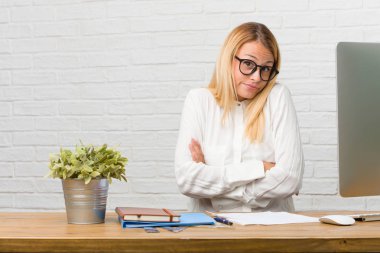 Şüphe ve shrugging görevleri yapmak onun masasına oturan genç öğrenci portresi omuzlar, kararsızlık ve güvensizlik, hakkında bir şey belirsiz kavram