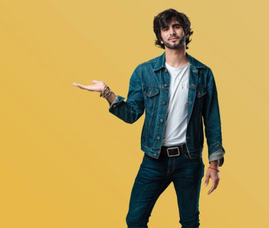 Elleriyle bir şey tutan, bir ürün, gülümseyen ve neşeli gösterilen, hayali bir nesne sunan yakışıklı delikanlı