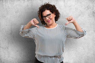 Orta yaşlı kadın gurur ve kendinden emin, işaret parmakları, örnek takip etmek, memnuniyeti, kibir ve sağlık kavramı