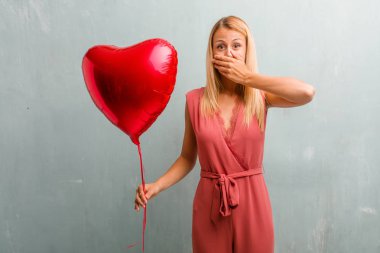 Bir şey söylemek çalışıyor ağız, sessizlik ve baskı, sembolü kapsayan zarif sarışın genç kadın portresi. Bir kırmızı kalp balon holding.