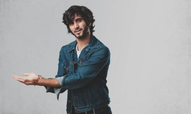 Elleriyle bir şey tutan, bir ürün, gülümseyen ve neşeli gösterilen, hayali bir nesne sunan yakışıklı delikanlı