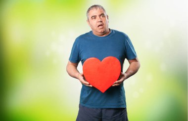 bir kalp şekli tutan olgun adam