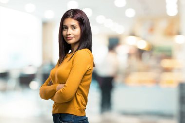 Kollarını, gülümseyen ve mutlu crossing, güvenli ve dost canlısı bir kafeteryada genç güzel kadın