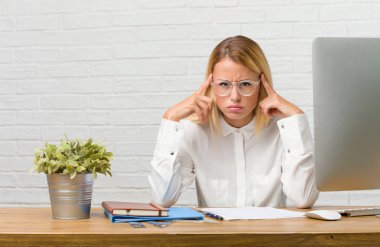 Bir konsantrasyon jest yaparak, bir hedefe dümdüz odaklı seyir görevleri adamın işi masasına oturan genç öğrenci portresi