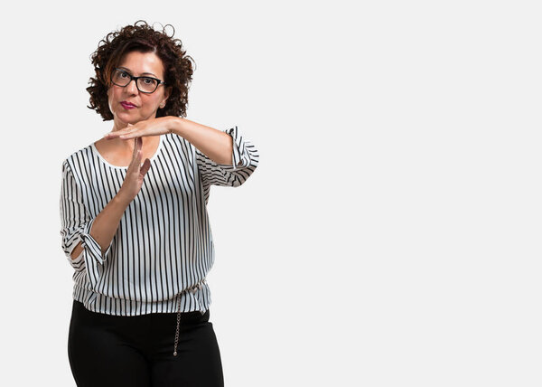 Женщина средних лет устал и скучно, делая тайм-аут жест, должен остановиться из-за стресса на работе, концепция времени
