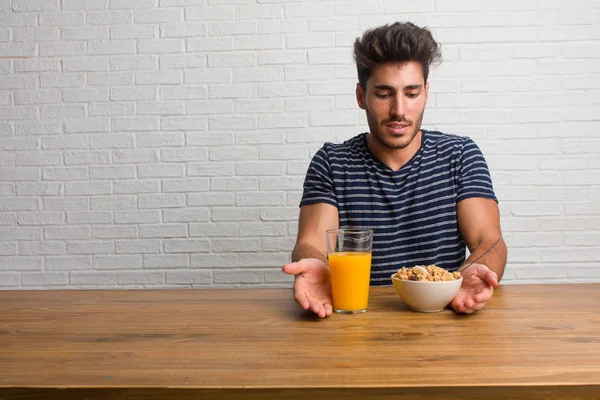 Joven Hombre Guapo Natural Sentado Una Mesa Sosteniendo Algo Con — Foto de Stock