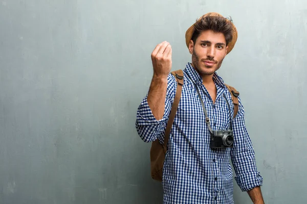 麦わら帽子 バックパックと典型的なイタリア ジェスチャー 笑みを浮かべて 真っすぐ前を見つめて シンボルや手で 非常に自然な表現をやって写真をカメラを着た若いハンサムな旅行者男 — ストック写真