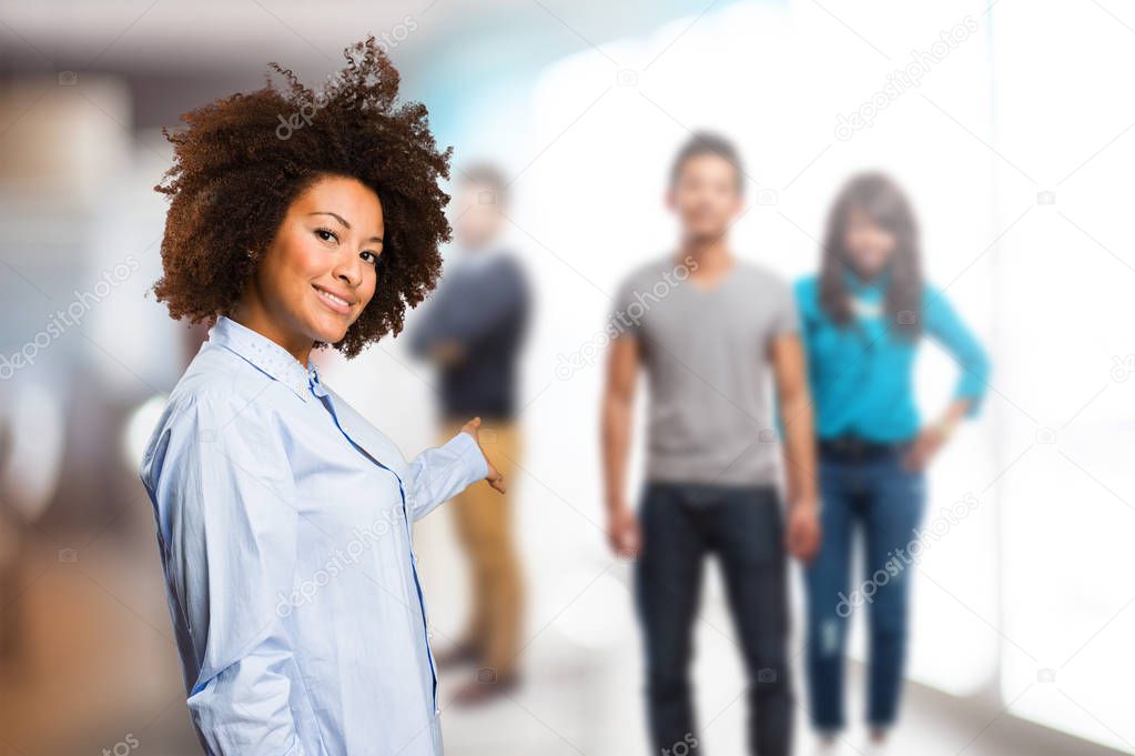 young black woman inviting someone to come with blurred people in background