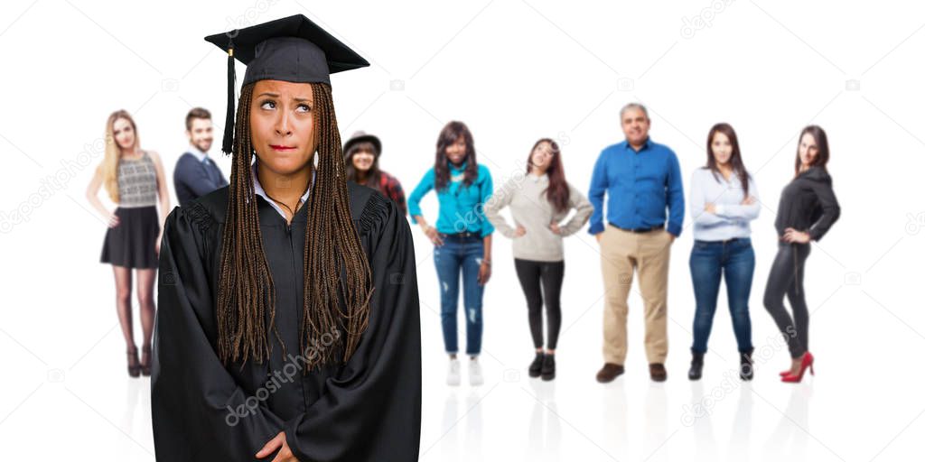 Young graduated black woman wearing braids doubting and confused, thinking of an idea or worried about something