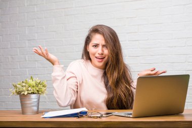 Çılgın ve umutsuz masanın üzerinde oturan genç öğrenci latin kadın portresi