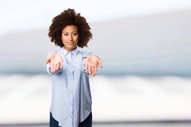 Genç siyah kadın üzerinde sunan bir şey arka plan bulanık