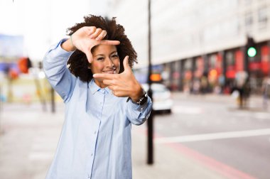 Genç siyah kadının arka plan bulanık çerçeve jest yapması