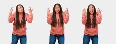 Fitness genç siyah kadın geçerken kümesi parmak, gri arka plan üzerinde şanslı olmak için dilek