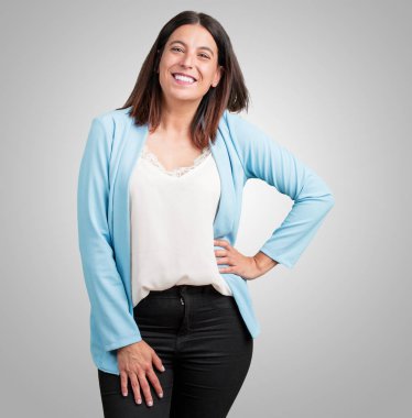 Kalça, ayakta, rahat ve gülümseyen, çok olumlu ve neşeli ellerinde olan orta yaşlı kadın