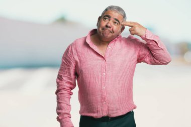 Orta yaşlı bir intihar jest yapma adam duygu üzgün ve korkmuş bir silah parmak ile şekillendirme