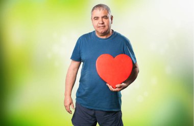bir kalp şekli tutan olgun adam