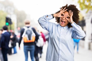 Genç siyah kadının arka plan bulanık gözlük jest yapması