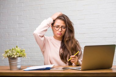 Boğulmuş ve endişeli masada oturan genç öğrenci latin kadın portresi