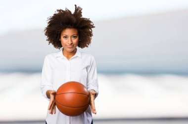 bir sepet topu tutan genç siyah kadın arka plan bulanık