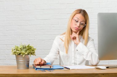 Görevleri şüphe ve karışık, düşünme, bir fikir ya da bir şey hakkında endişeli masasına oturan genç öğrenci portresi