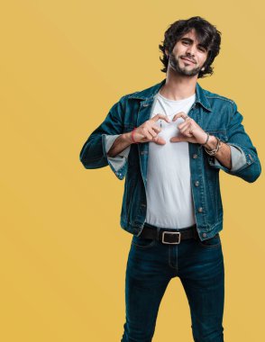 Sevgi ve dostluk, mutlu ve gülümseyerek kavramı ifade genç yakışıklı adam bir kalp el ile yapma