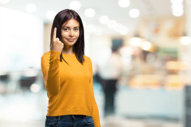 Genç güzel kadın gösteren bir numaralı simgesi sayma, matematik, kendinden emin ve neşeli bir kafeteryada kavramı