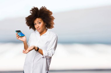 bir hesap makinesi üzerinde arka plan bulanık kullanan genç siyah kadın