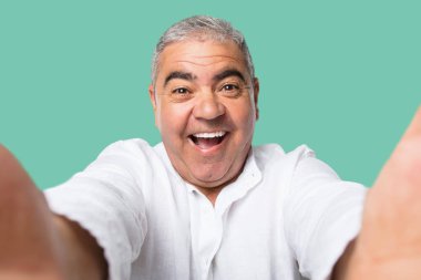 Orta yaşlı adam gülümseyen ve mutlu bir selfie üzerinde yeşil arka plana alarak