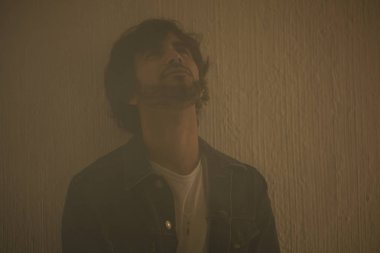 Genç yakışıklı adam neşeli ve kendine güvenen ayakta duvara kapalı 