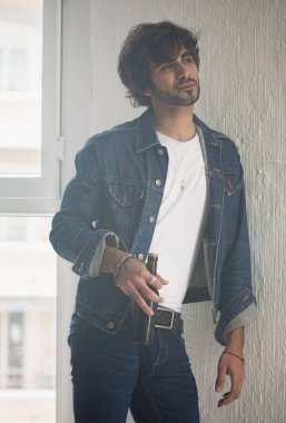 Genç yakışıklı adam neşeli ve kendine güvenen bira şişesi holding