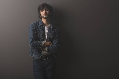 Genç yakışıklı adam neşeli ve kendine güvenen Studio kamera bakıyor 