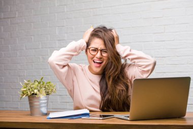 Sinirli ve umutsuz masanın üzerinde oturan genç öğrenci latin kadın portresi