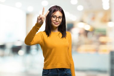 Genç güzel kadın gösteren ikinci sayım simgesi, matematik, kendinden emin ve neşeli bir kafeteryada kavramı