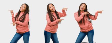 Gri arka tarafta işaret eden fitness genç siyah kadın ayarla