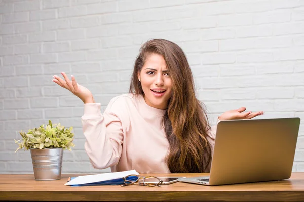 Çılgın ve umutsuz masanın üzerinde oturan genç öğrenci latin kadın portresi