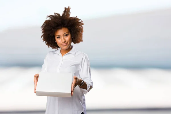 Jonge Zwarte Vrouw Met Een Witte Doos Onscherpe Achtergrond — Stockfoto