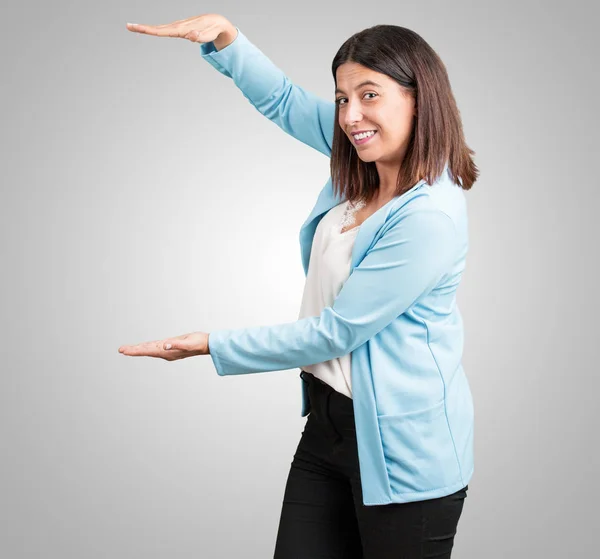 Midden Leeftijd Vrouw Houden Iets Met Handen Tonen Van Een — Stockfoto