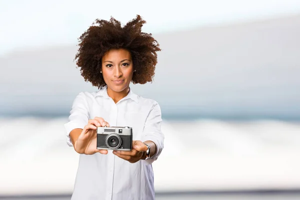 背景をぼかした写真にビンテージ カメラを使用して若い黒人女性 — ストック写真