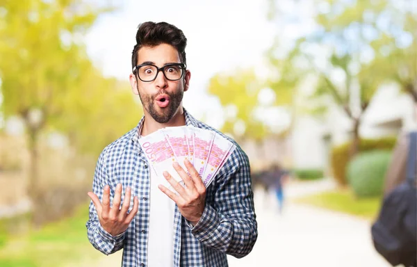 young man winning money on blurred background