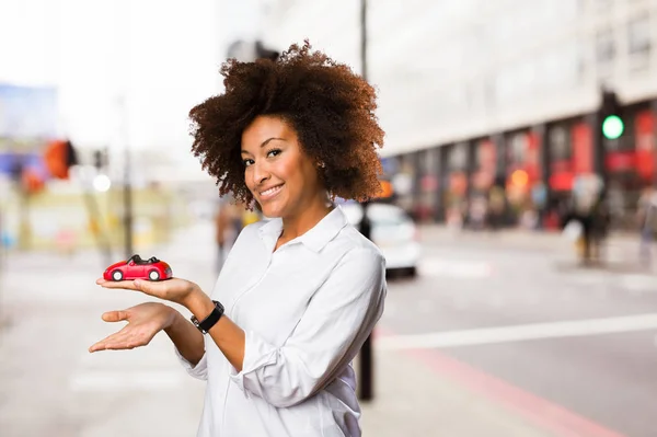 Młoda Kobieta Czarny Trzymając Czerwony Samochód Niewyraźne Tło — Zdjęcie stockowe