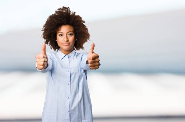 Genç siyah kadının arka plan bulanık iyi jest yapması