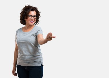 Pozitif ve güler yüzlü kadın gel, kendinden emin ve gülümseyen bir hareketi el ile yapmak için davet orta yaşlı
