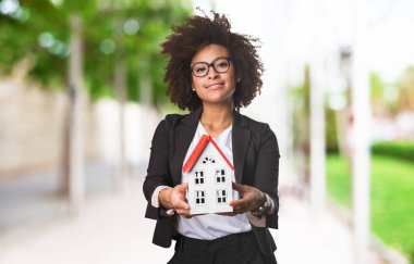 arka plan bulanık üzerinde küçük bir ev tutarak siyah iş kadını