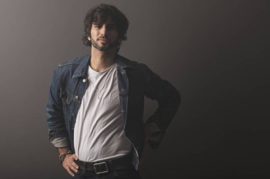 Genç yakışıklı adam neşeli ve kendine güvenen Studio kamera bakıyor 